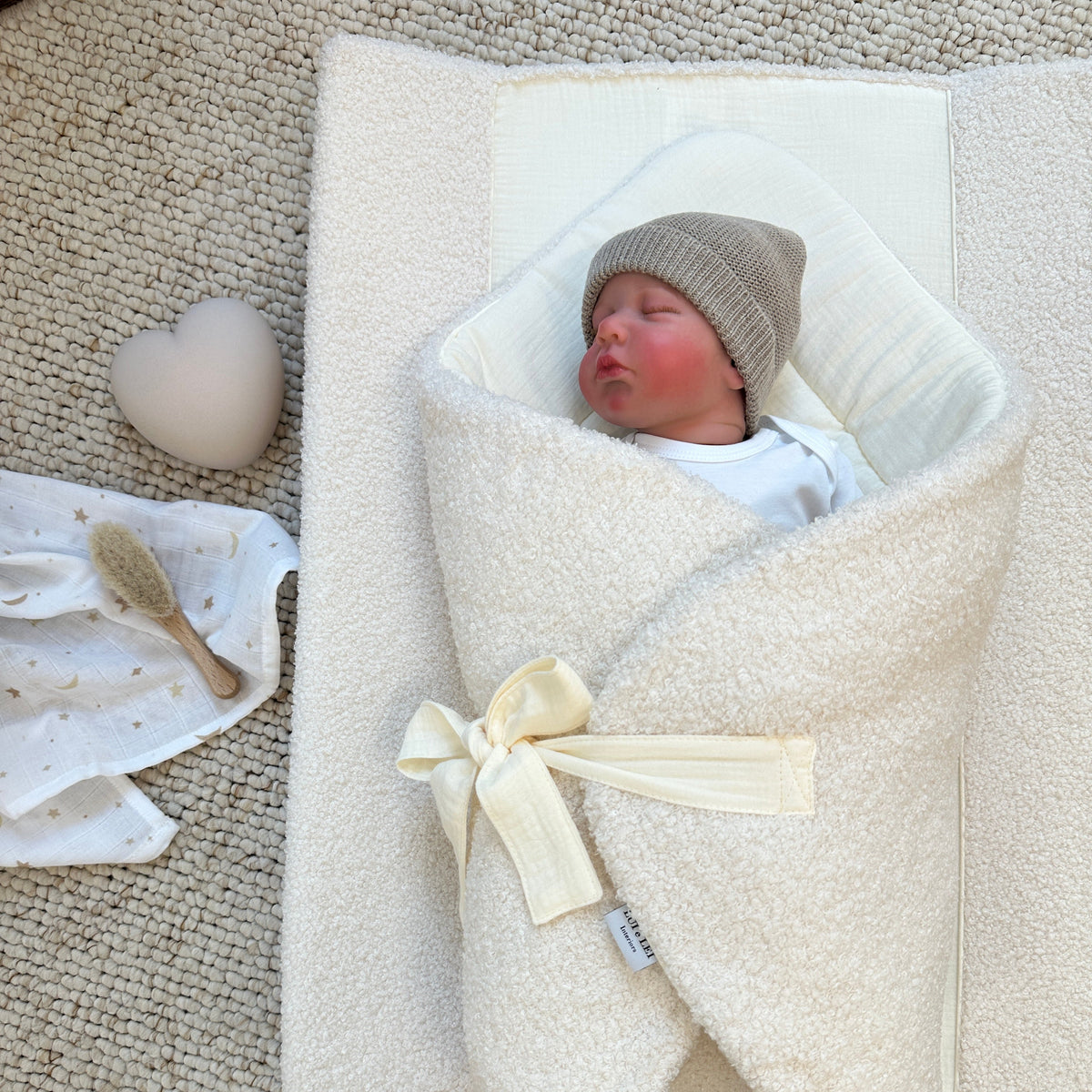 Baby liegt auf Lui e Lei Wickelauflage aus Bio-Baumwolle und Boucle in vanille