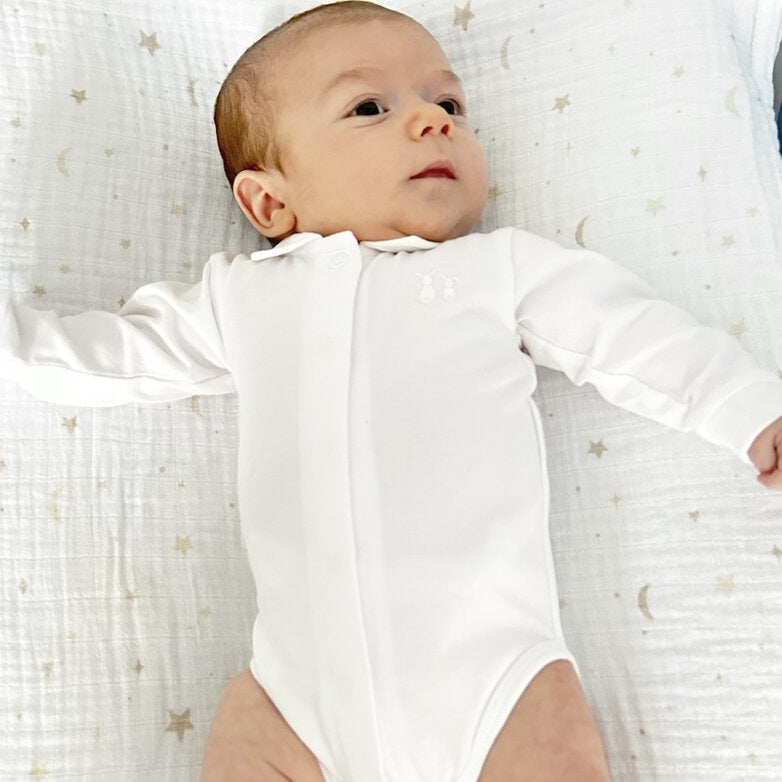 Baby liegt auf einem Pucktuch mit Mond &amp; Sternen von Poetree Kids 